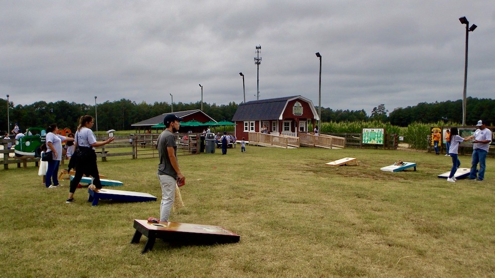 Families enjoying a game of cornhole at SCI Family Fun Day.