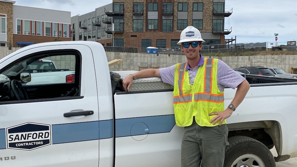 Garrett Russell stands in front Sandford Contractor truck.