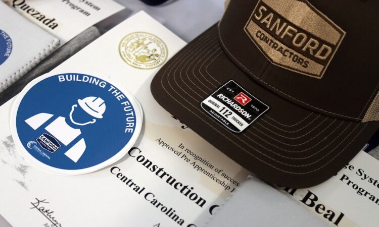 Close up shot of Sanford Contractors hat alongside the certificate from the SCI Construction Academy.