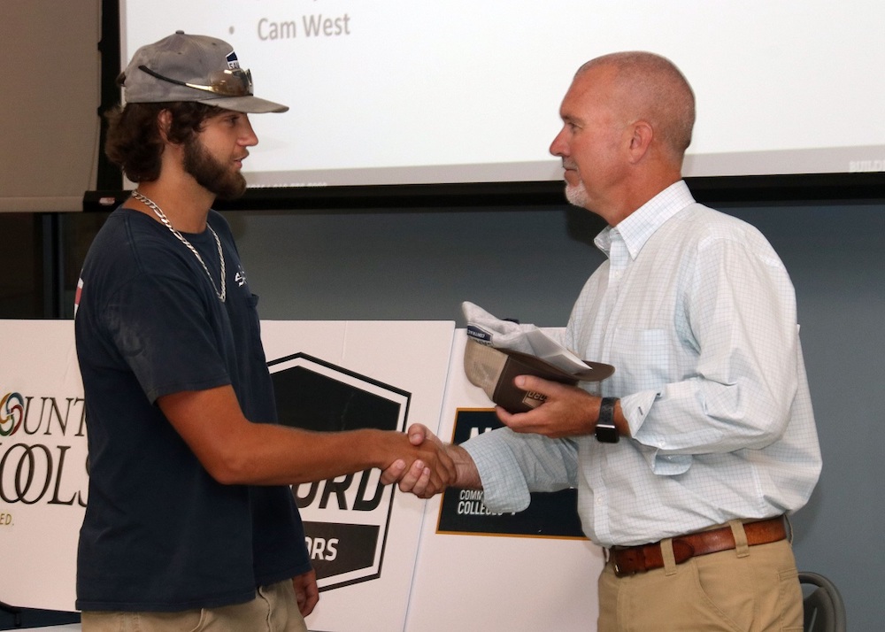 Zac West shaking hands with one of the graduates from the SCI Construction Academy.