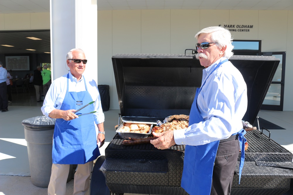 Two men serving BBQ at grill