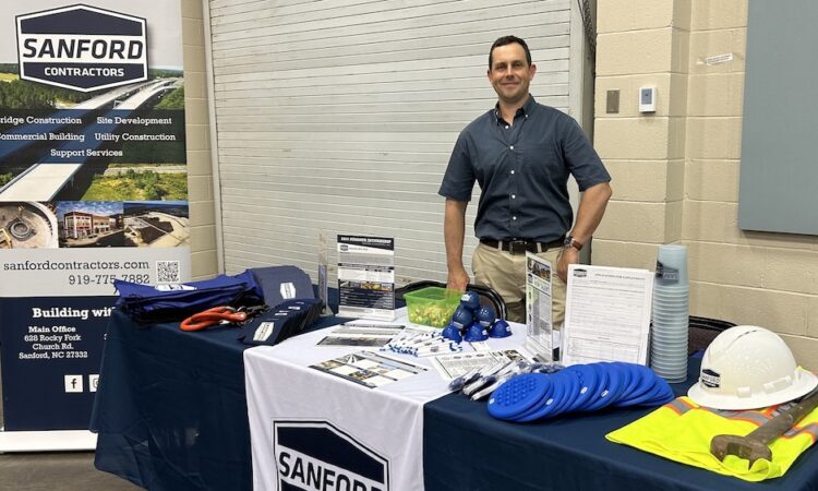 Kyle Winters poses at SCI table at recent community event.