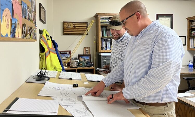 Justin Carter and Matthew Spatz look over construction plans in SCI offices.