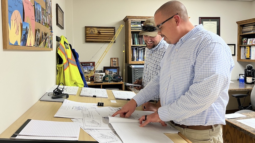 Justin Carter and Matthew Spatz look over construction plans in SCI offices.